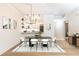 Bright dining room with a modern chandelier, seating, and an open view of the updated kitchen area at 273 12Th Ne St # 114, Atlanta, GA 30309