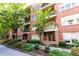 Beautiful brick condo building showcasing multiple balconies, a tree-lined street, and meticulously landscaped gardens at 273 12Th Ne St # 114, Atlanta, GA 30309