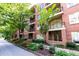Brick apartment building with balconies, flowers, green foliage, and a street view at 273 12Th Ne St # 114, Atlanta, GA 30309