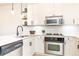 Bright kitchen featuring white cabinets, floating shelves, stainless appliances and a modern faucet fixture at 273 12Th Ne St # 114, Atlanta, GA 30309