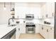 Bright kitchen featuring white cabinets, floating shelves, stainless appliances and a modern faucet fixture at 273 12Th Ne St # 114, Atlanta, GA 30309
