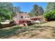 Home exterior with a brick foundation, inviting deck, sunroom, and a beautifully landscaped yard, ideal for entertaining at 4172 Whispering Forest Ct, Lilburn, GA 30047
