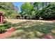 Spacious backyard with lush green grass, mature trees, and a tranquil seating area, perfect for outdoor relaxation at 4172 Whispering Forest Ct, Lilburn, GA 30047
