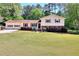 Charming two-story home with a well-manicured lawn, a two-car garage, and mature trees surrounding the property at 4172 Whispering Forest Ct, Lilburn, GA 30047