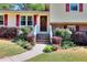 Inviting entryway with a wooden door, decorative wreath, and colorful landscaping enhancing the home's curb appeal at 4172 Whispering Forest Ct, Lilburn, GA 30047