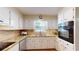 Well-lit kitchen with granite countertops, white cabinets, and stainless steel appliances providing a clean and functional space at 4172 Whispering Forest Ct, Lilburn, GA 30047