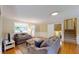 Comfortable living room with hardwood floors, gray sofas, and a view of the stairway and back entryway at 4172 Whispering Forest Ct, Lilburn, GA 30047