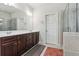 Elegant bathroom featuring double sinks, dark wood cabinets, and a glass-enclosed shower at 1645 Dahlia Dr, Cumming, GA 30040