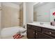 Cozy bathroom featuring a bathtub with tile surround and a dark wood vanity at 1645 Dahlia Dr, Cumming, GA 30040