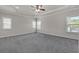 Large bedroom featuring tray ceilings with a fan and multiple windows with blinds at 1645 Dahlia Dr, Cumming, GA 30040