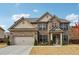 Charming two-story brick home with a well-manicured lawn and attached two-car garage at 1645 Dahlia Dr, Cumming, GA 30040