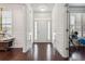 Bright foyer featuring hardwood floors, white wainscoting, and a view of the front door and transom window at 1645 Dahlia Dr, Cumming, GA 30040