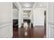 Hallway with hardwood floors, white wainscoting, and views into the living room and dining areas at 1645 Dahlia Dr, Cumming, GA 30040