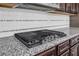 Gourmet kitchen featuring granite countertops, tile backsplash, and a stainless steel gas cooktop at 1645 Dahlia Dr, Cumming, GA 30040
