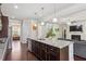Open-concept kitchen with dark wood cabinets, a granite island, and stainless-steel appliances at 1645 Dahlia Dr, Cumming, GA 30040