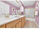 Bright bathroom featuring double sinks, spacious vanity, and shower with glass doors at 200 Boca Ciega Ct, Alpharetta, GA 30022