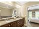 A bathroom features double sinks, granite counters, a bathtub, and mirrors at 25 High Gate Trail, Atlanta, GA 30030