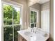 Bathroom with a white vanity and natural light shining through the window with trees outside at 25 High Gate Trail, Atlanta, GA 30030