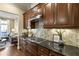 Modern kitchen with dark wood cabinets, granite countertops, and stainless steel appliances at 25 High Gate Trail, Atlanta, GA 30030