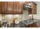 Gourmet kitchen with dark wood cabinets, stainless steel hood, and mosaic tile backsplash at 25 High Gate Trail, Atlanta, GA 30030