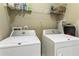 Functional laundry room with white washer and dryer, and storage shelves at 25 High Gate Trail, Atlanta, GA 30030