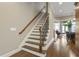 Staircase with wood treads, iron balusters, and a view into the dining and living areas at 25 High Gate Trail, Atlanta, GA 30030
