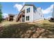Backyard view of light gray two-story home with a wooden staircase leading to a deck and blue sky at 460 Marston Pass, Acworth, GA 30102
