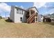 Backyard view of light gray two-story homes with wooden staircases leading to a decks and blue sky at 460 Marston Pass, Acworth, GA 30102