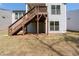 Backyard view of light gray two-story home with a wooden staircase leading to a deck with a small area under the deck at 460 Marston Pass, Acworth, GA 30102