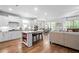 Open kitchen and living area featuring white cabinets, a large island and stainless appliances at 460 Marston Pass, Acworth, GA 30102