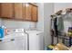 Functional laundry room with washer, dryer, storage cabinets, and a rack for hanging clothes at 460 Marston Pass, Acworth, GA 30102