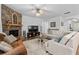Cozy living room with stone fireplace, ceiling fan, plush couches, and large windows for ample natural light at 460 Marston Pass, Acworth, GA 30102