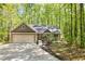 A beautifully landscaped home, featuring a two-car garage, with mature trees providing privacy and a scenic backdrop at 191 Orchard Dr, Canton, GA 30115