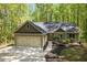 A home boasts a two-car garage, complemented by lush landscaping, a charming walkway, and vibrant greenery at 191 Orchard Dr, Canton, GA 30115