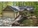 Beautifully landscaped home with a two-car garage, complemented by a charming walkway and lush greenery at 191 Orchard Dr, Canton, GA 30115
