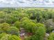 Overhead view displays the house among lush, mature trees and landscaping, featuring a spacious deck and detached storage building at 2086 Harold Se Ave, Smyrna, GA 30080