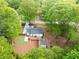 Aerial view showcasing the house with a large deck, fenced yard, storage building, and surrounding mature trees at 2086 Harold Se Ave, Smyrna, GA 30080