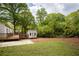 Extensive backyard with deck, outbuilding and manicured lawn with beautiful green trees at 2086 Harold Se Ave, Smyrna, GA 30080
