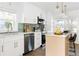 Modern kitchen with white cabinets, stainless steel appliances, stylish backsplash and an island with seating at 2086 Harold Se Ave, Smyrna, GA 30080