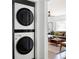 Modern laundry area with stacked washer and dryer next to a living room area at 2086 Harold Se Ave, Smyrna, GA 30080
