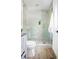 Bright bathroom features a glass shower with stone floor, gold hardware, and white vanity at 2086 Harold Se Ave, Smyrna, GA 30080