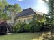 Exterior view of the home showcasing a well-kept lawn, mature trees, and landscaping at 4383 Post Rd, Winston, GA 30187