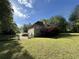 View of home's rear exterior showing well-maintained lawn, fencing, and lush, mature trees at 4383 Post Rd, Winston, GA 30187