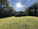 Exterior view of a home surrounded by a lush lawn and mature trees under a bright sky at 4383 Post Rd, Winston, GA 30187