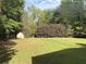 Spacious backyard featuring a well-maintained lawn, mature landscaping, and a storage shed at 4383 Post Rd, Winston, GA 30187