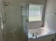 Bathroom featuring a bathtub and glass door shower, illuminated by natural light from a window at 4383 Post Rd, Winston, GA 30187