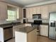 Kitchen featuring stainless steel appliances, wooden cabinets, an island, and wooden floors at 4383 Post Rd, Winston, GA 30187