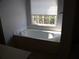 Bathroom features a luxurious soaking tub next to a bright window at 4909 Farm Valley Ne Dr, Woodstock, GA 30188