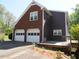 Brick and brown sided home features a two car garage and wooden deck at 4909 Farm Valley Ne Dr, Woodstock, GA 30188