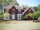 Charming two-story brick home with a well-maintained lawn and mature trees at 4909 Farm Valley Ne Dr, Woodstock, GA 30188